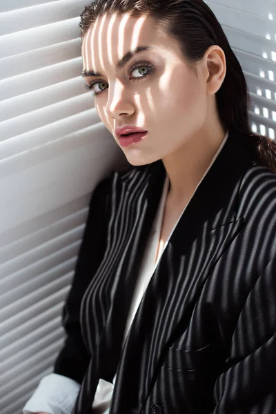 Fashionable glamour girl in black suit with shadows on face — Stock Photo