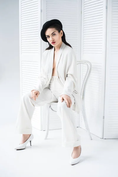 Модная модель в белом костюме и винтажной шляпе — стоковое фото