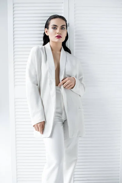 Красивая полуголая женщина позирует в белом стильном костюме — стоковое фото