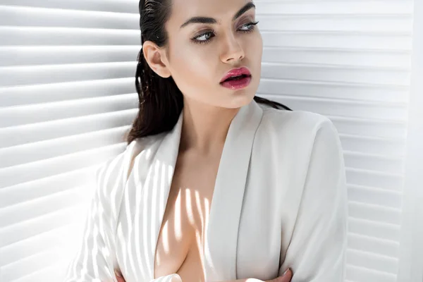Привлекательная элегантная модель, позирующая в модной белой куртке с тенями — стоковое фото