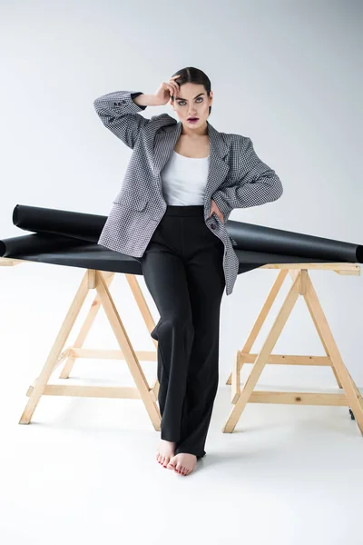 Модная элегантная женщина позирует в винтажном пиджаке, на сером — стоковое фото