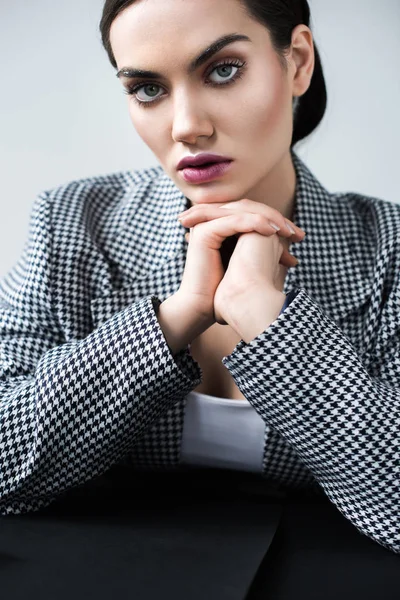 Modische Frau mit Make-up posiert im eleganten Retro-Anzug, auf grau — Stockfoto