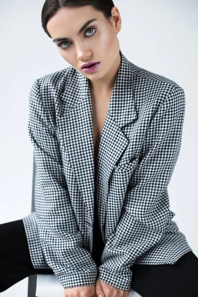 Привлекательная девушка позирует в винтажной элегантной куртке, изолированной на сером — стоковое фото