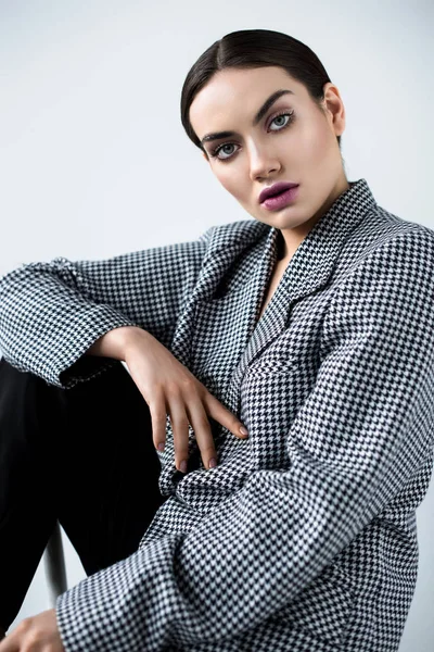 Beautiful fashionable girl with makeup posing in vintage elegant jacket, isolated on grey — Stock Photo