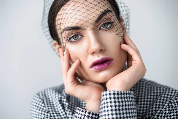 Schönes Mädchen mit Make-up posiert in Jacke und Vintage-Netzschleier, isoliert auf grau — Stockfoto