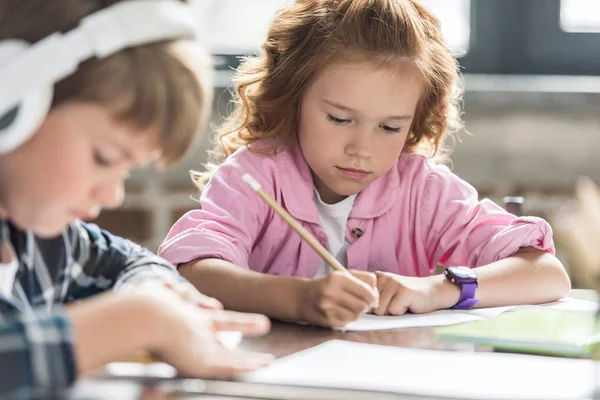 Close-up shot of little brother and sister doing homework — Stock Photo