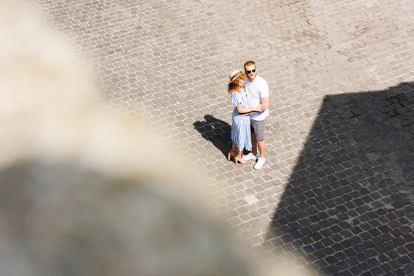 Селективное внимание рыжеволосой пары, обнимающей друг друга на городской улице — стоковое фото