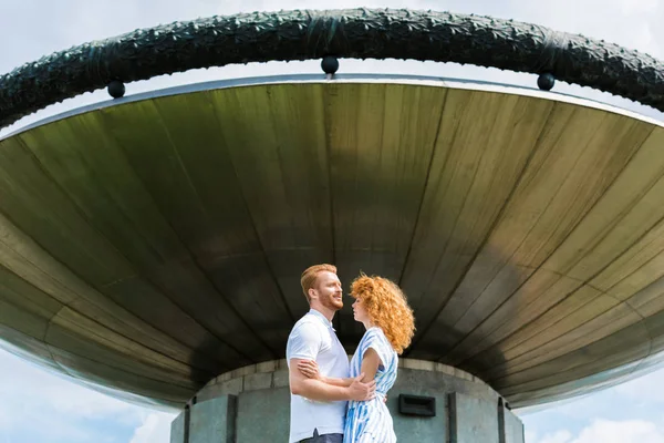 Couple rousse s'embrassant devant un bâtiment moderne — Photo de stock