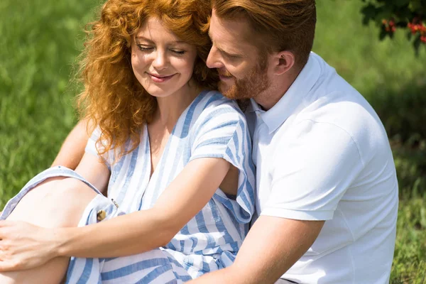 Felice rossa uomo abbracciare fidanzata su erba all'aperto — Foto stock