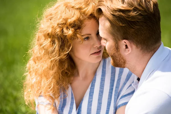 Selective focus of redhead couple looking at each other outdoors — Stock Photo