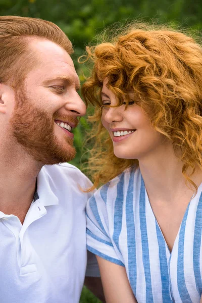 Retrato de pareja pelirroja feliz con los ojos cerrados al aire libre - foto de stock