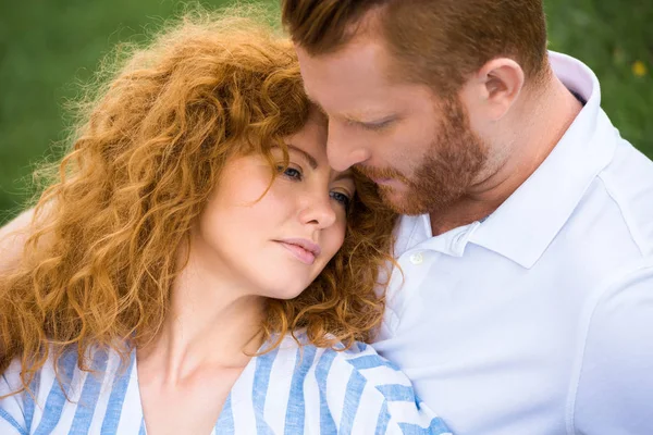 Attractive redhead woman laying on boyfriend shoulder — Stock Photo