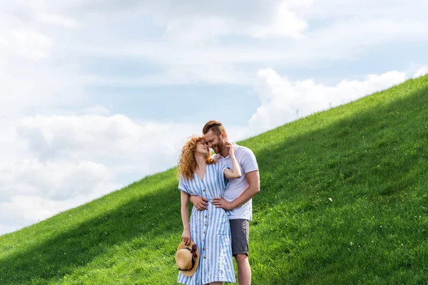 Redhead couple embracing each other on green hill — Stock Photo