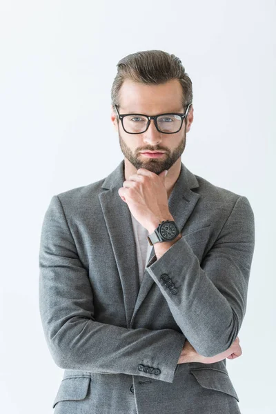 Homem de negócios pensativo em óculos e terno cinza com relógio de pulso na mão, isolado em branco — Fotografia de Stock