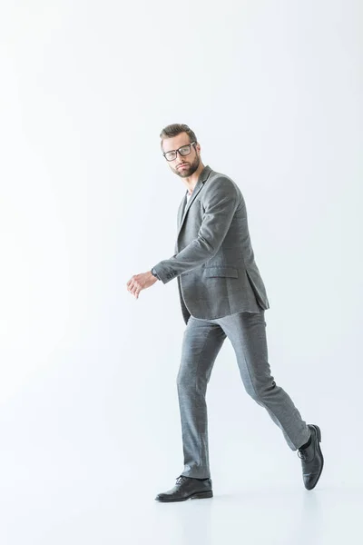 Hombre de negocios elegante caminando en ropa formal gris, aislado en blanco - foto de stock