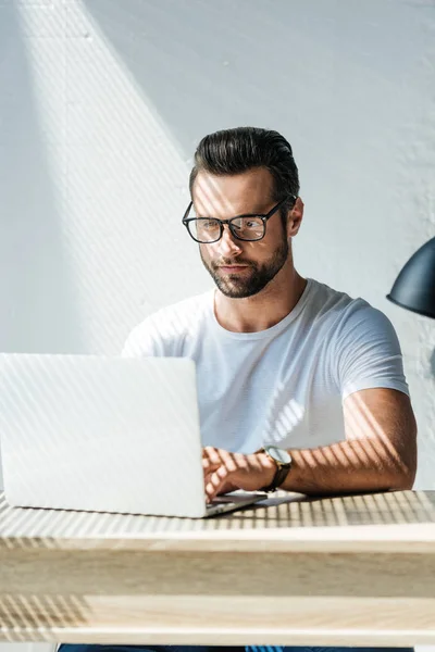 Красивый брюнет мужчина, работающий с ноутбуком — стоковое фото