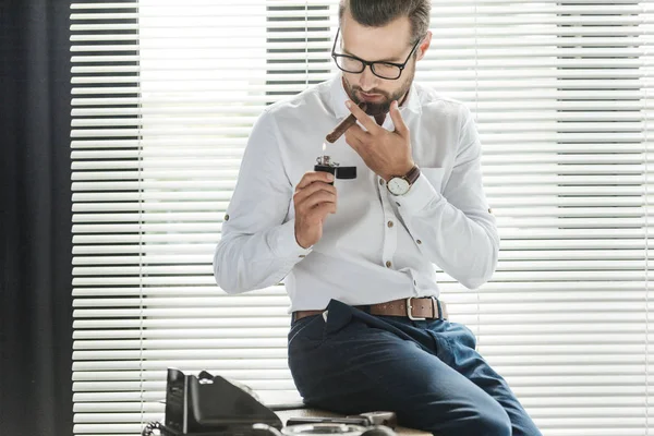 Businessman with lighter smoking cigar at workplace with rotary telephone — Stock Photo