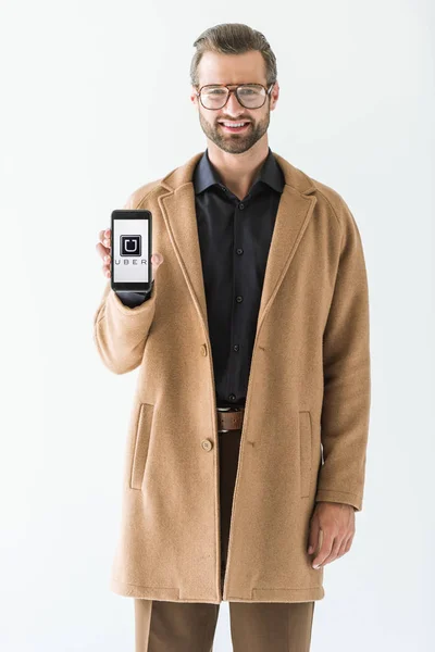 Hombre sonriente guapo presentando smartphone con uber appliance, aislado en blanco - foto de stock