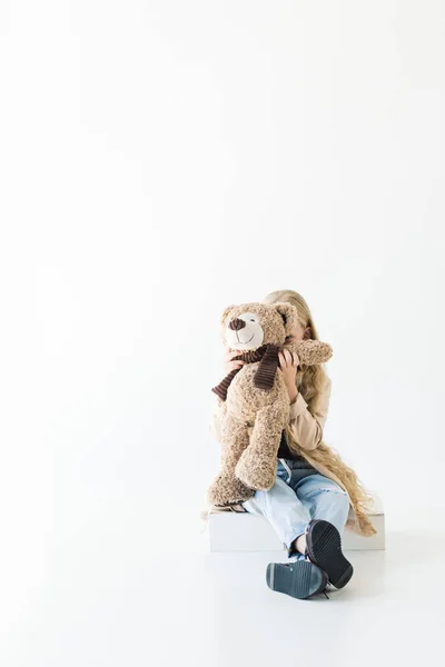 Adorable petit enfant étreignant ours en peluche isolé sur blanc — Photo de stock