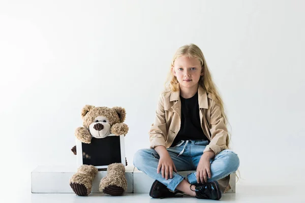 Teddy bear with digital tablet and beautiful smiling stylish kid with long curly hair on white — Stock Photo