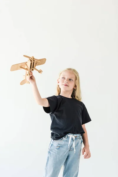 Linda criança brincando com avião de brinquedo de madeira isolado no branco — Fotografia de Stock