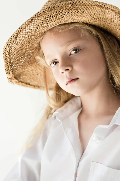 Portrait of beautiful little kid in wicker hat looking at camera on white — Stock Photo