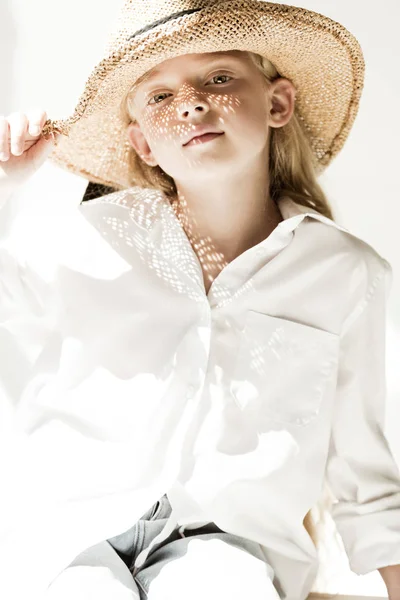 Portrait de mignon petit enfant en chapeau de paille regardant caméra sur blanc — Photo de stock