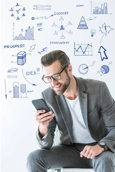 Desarrollador SEO con estilo en traje gris usando teléfono inteligente, aislado en blanco con iconos de éxito - foto de stock