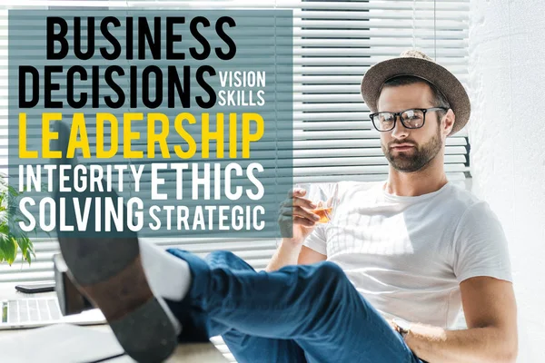 Stylish businessman holding glass of whiskey, with leadership lettering — Stock Photo
