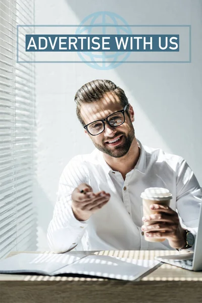 Exitoso desarrollador seo sentado en el lugar de trabajo con taza de café, con letras 