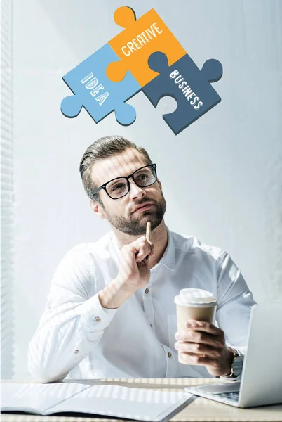 Thoughtful businessman sitting at workplace with idea, creative, business words puzzle — Stock Photo