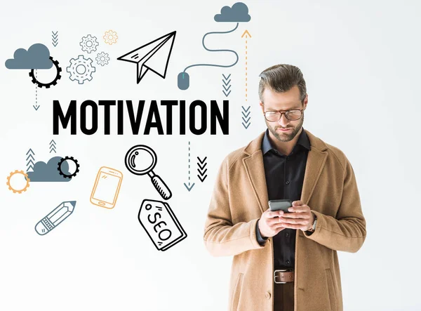 Handsome developer in brown coat using smartphone, isolated on white with SEO motivation icons — Stock Photo