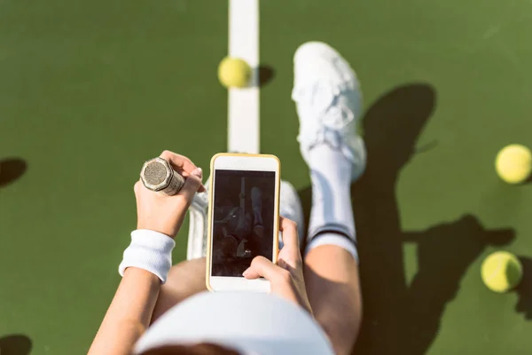 Vue aérienne d'une joueuse de tennis avec raquette se prenant en photo sur un court de tennis — Photo de stock