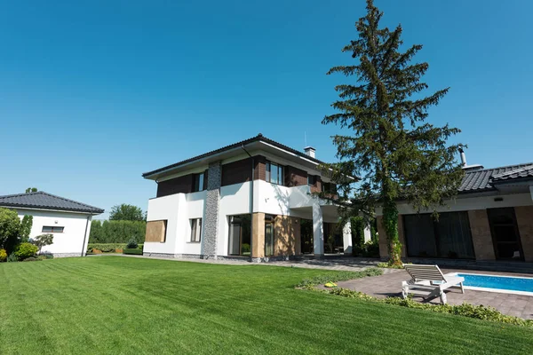 Vue de la nouvelle maison moderne avec piscine et pelouse verte — Photo de stock