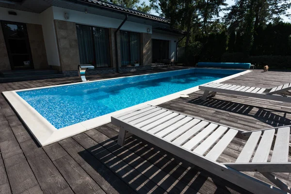 Vista de la casa exterior, piscina con tumbonas - foto de stock