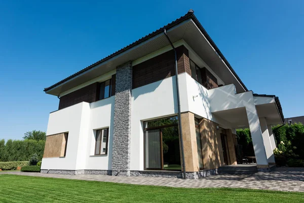 Outside view of modern house with green lawn — Stock Photo