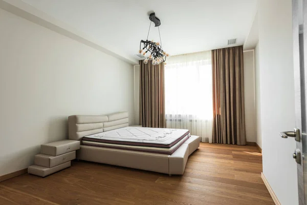 Interior of empty bedroom with big window and mattress on bed — Stock Photo