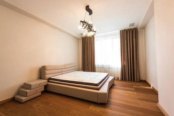 Intérieur de la chambre élégante avec grande fenêtre et matelas sur le lit — Photo de stock