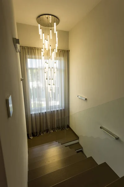 Interior view of empty stairs with glass railings and elegant chandelier — Stock Photo