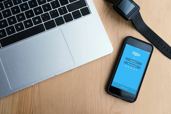 Top view of laptop, smartwatch and smartphone with skype app on screen — Stock Photo