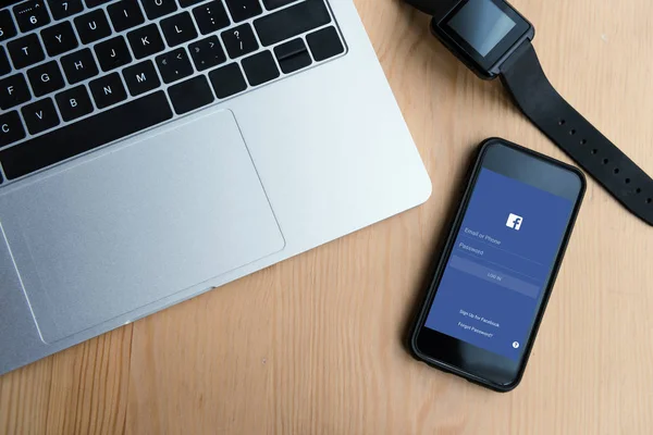 Top view of laptop, smartwatch and smartphone with facebook application on screen — Stock Photo