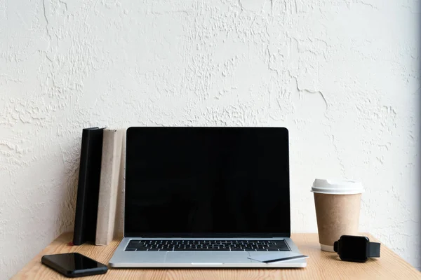 Laptop, Smartphone, Smartwatch und Kaffee to go auf Holztisch — Stockfoto