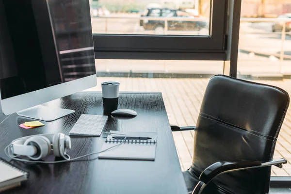 Столик с компьютером и чашка кофе в офисе — стоковое фото
