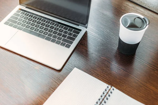 Vue grand angle de l'ordinateur portable et tasse de café sur la table dans le bureau — Photo de stock