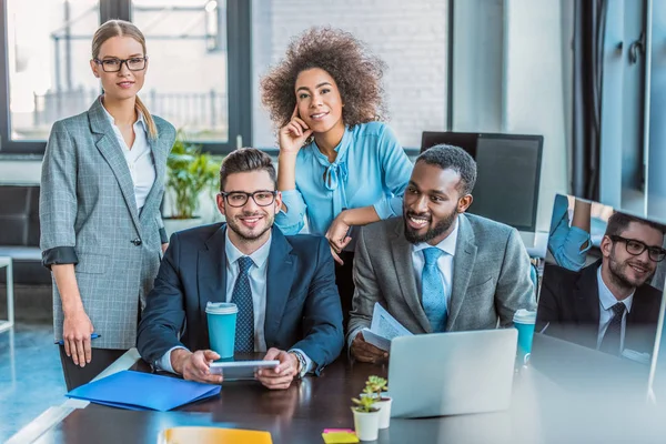 Souriants entrepreneurs multiculturels regardant la caméra dans le bureau — Photo de stock