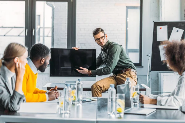 Multicultural businesspeople looking at computer screen during meeting in office — Stock Photo