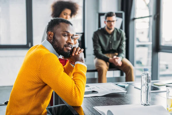 Vista lateral del pensativo hombre de negocios afroamericano en la reunión en el cargo - foto de stock