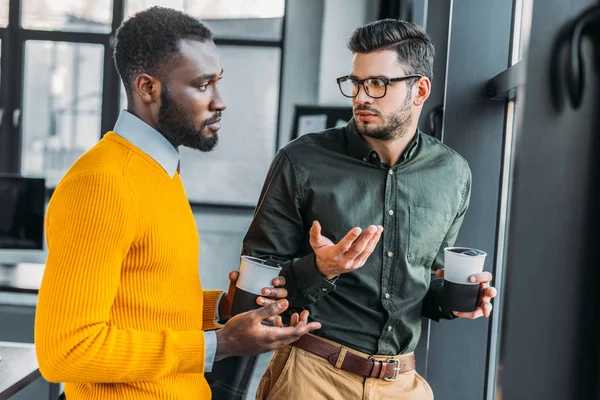 Uomini d'affari multiculturali che parlano durante la pausa caffè in ufficio — Foto stock