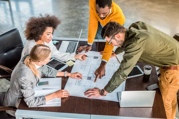 High angle view of african american businessman pointing on something at blueprint in office — Stock Photo