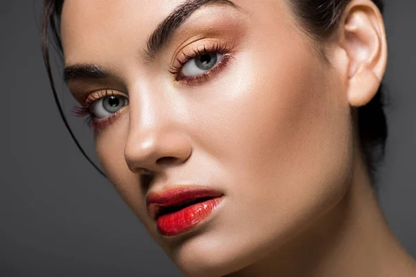 Attraktives modisches Modell mit Make-up im Gesicht, isoliert auf grau — Stockfoto